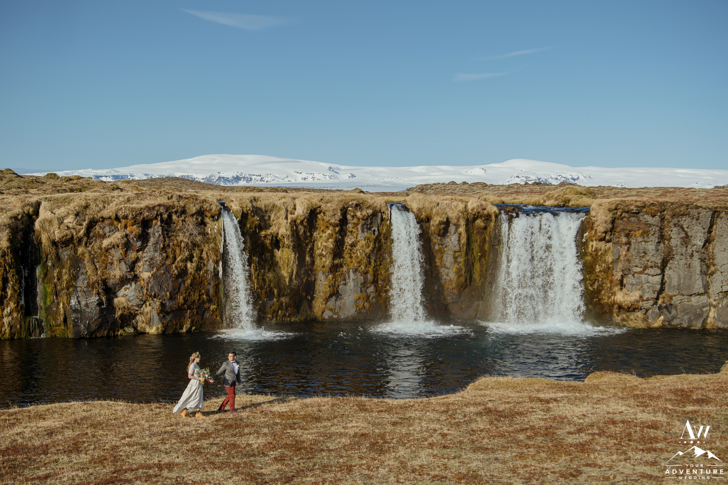 Iceland Wedding Couple Walking in front of a waterfall
