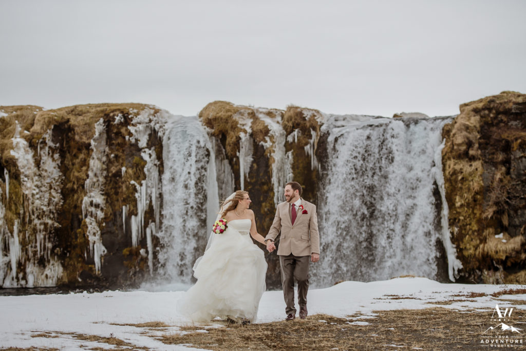 Iceland Wedding Couple walking in front of a private waterfall