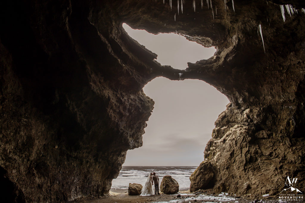 Couple inside of hjorleifshofdi cave during wedding adventure