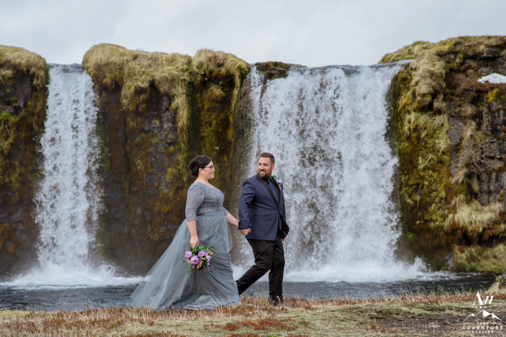 Iceland Wedding Couple walking in front of a waterfall