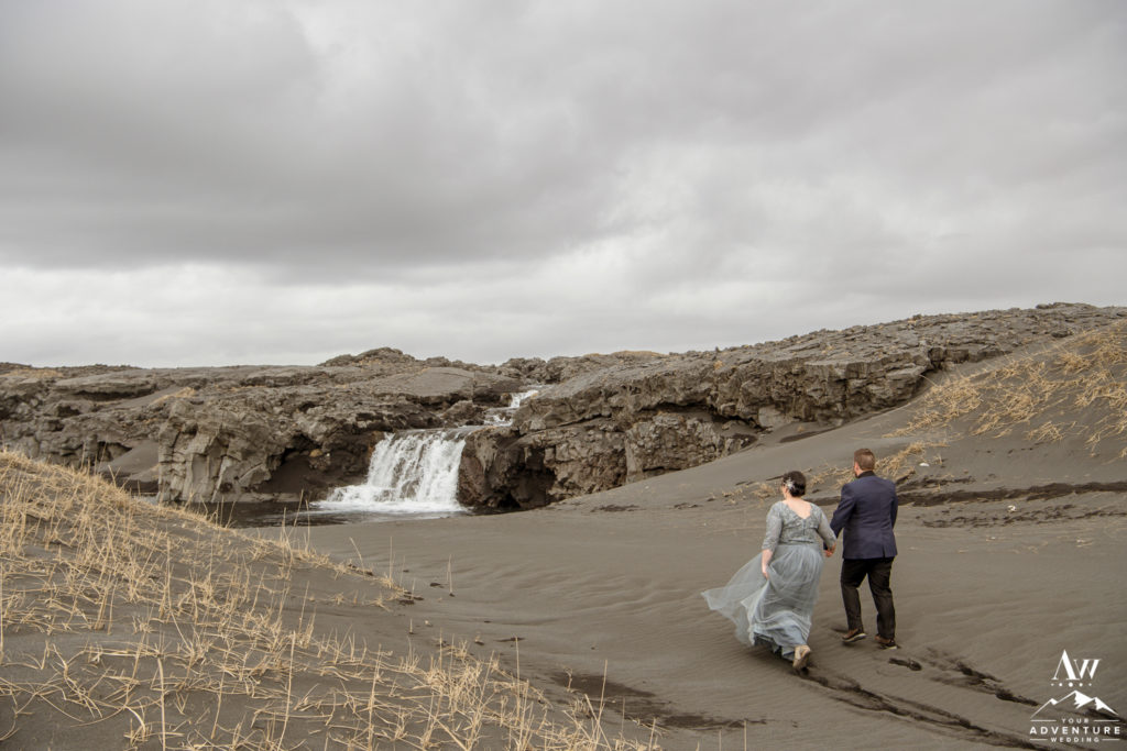 Iceland Elopement Couple Walking towards black beach waterfall