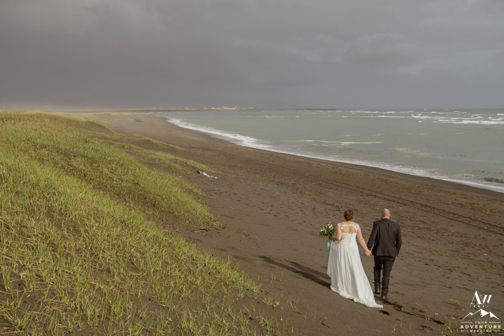 Couple walking on black sand beach in Iceland