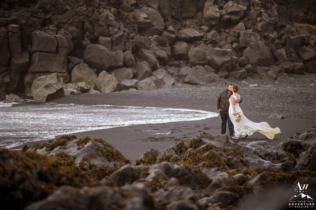 Couple kissing during Iceland adventure wedding black beach
