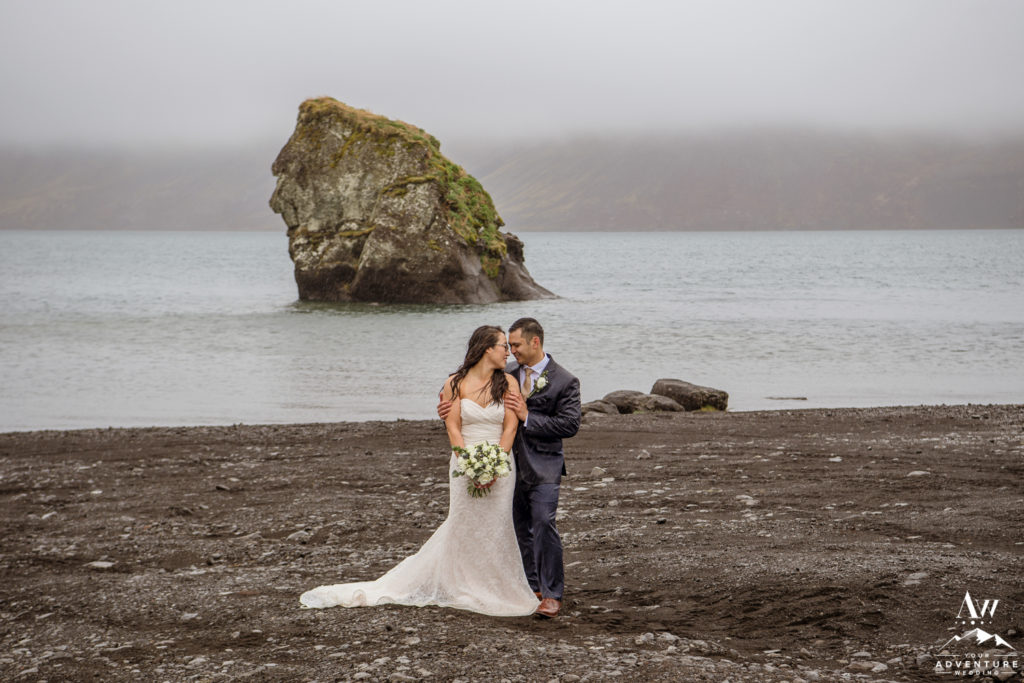 Couple cuddling during rainy Iceland wedding day