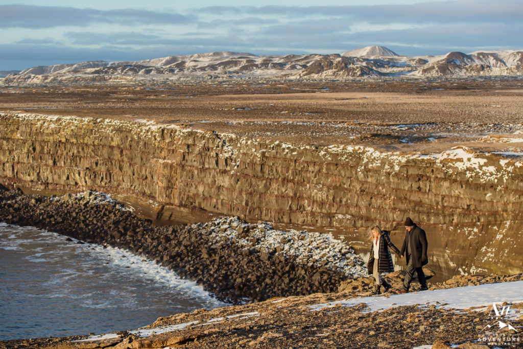 Iceland Engagement Couple walking on Golden Cliffs