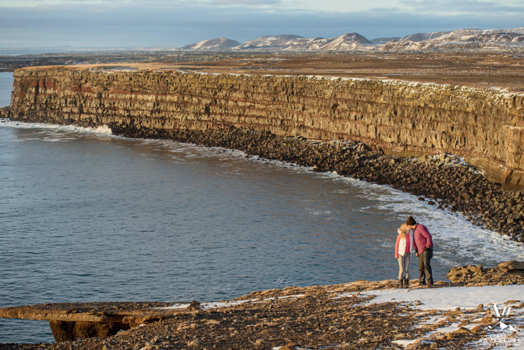 Iceland Proposal Couple Kissing on top of Golden Cliffs