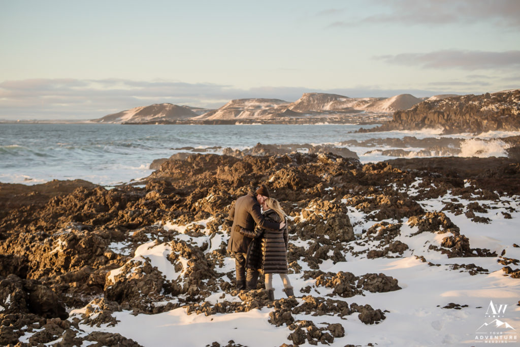 Iceland Engagement Couple kissing on lava rock beach