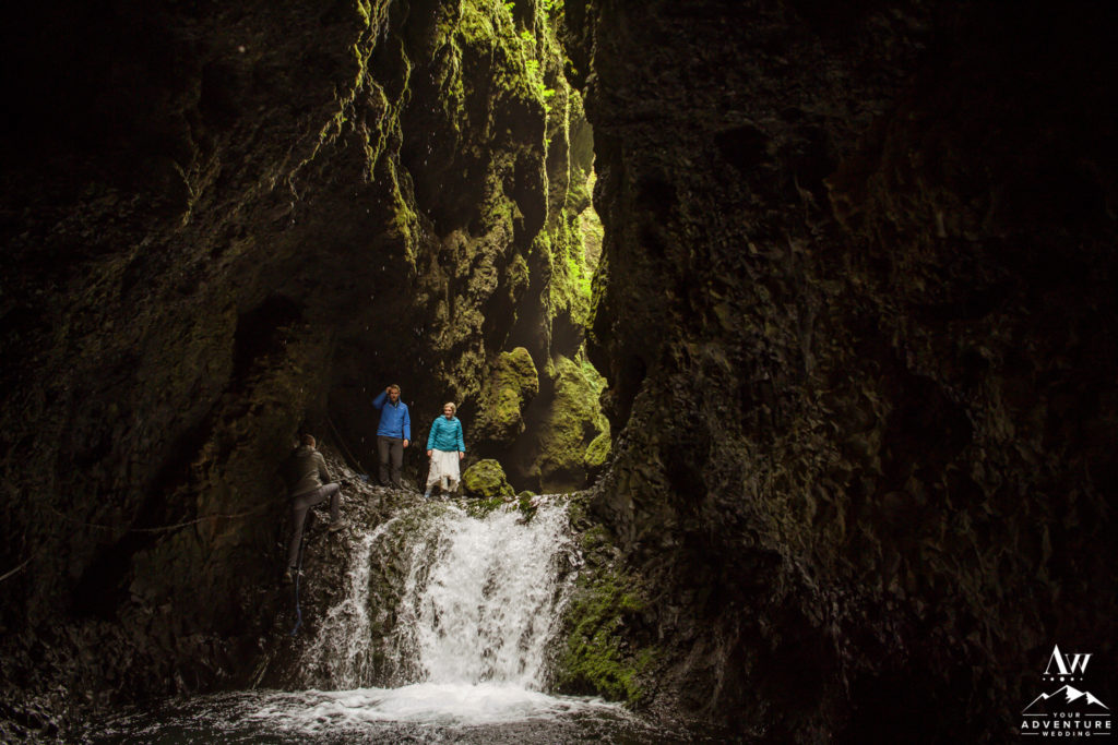 Iceland wedding couple rock climbing up a waterfall