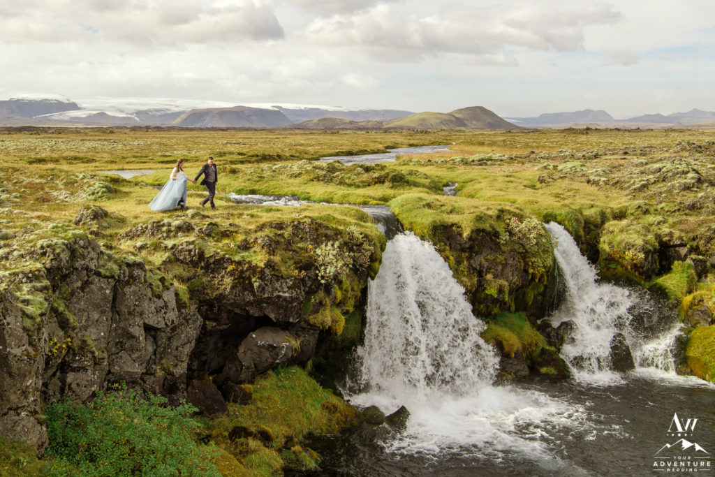 Photo of couple on top of waterfall by Vik Elopement Photographer
