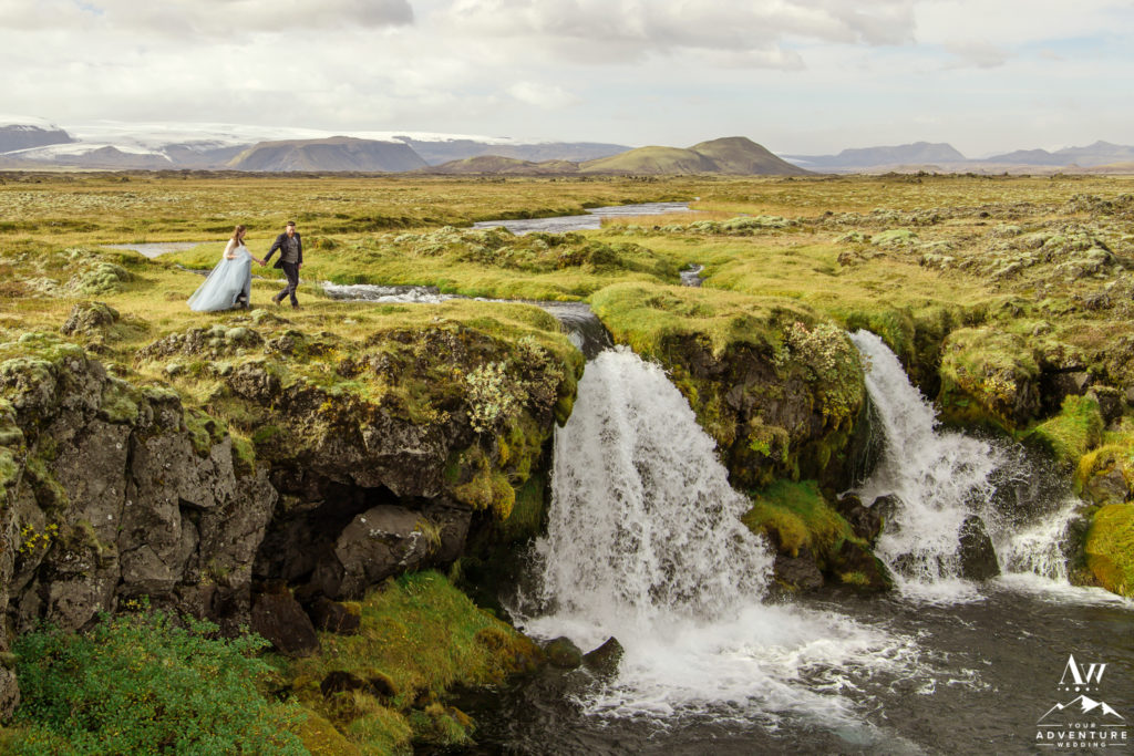 Photo of couple on top of waterfall by Vik Elopement Photographer