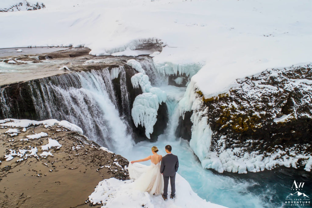 February Iceland Wedding Couple on top of a waterfall