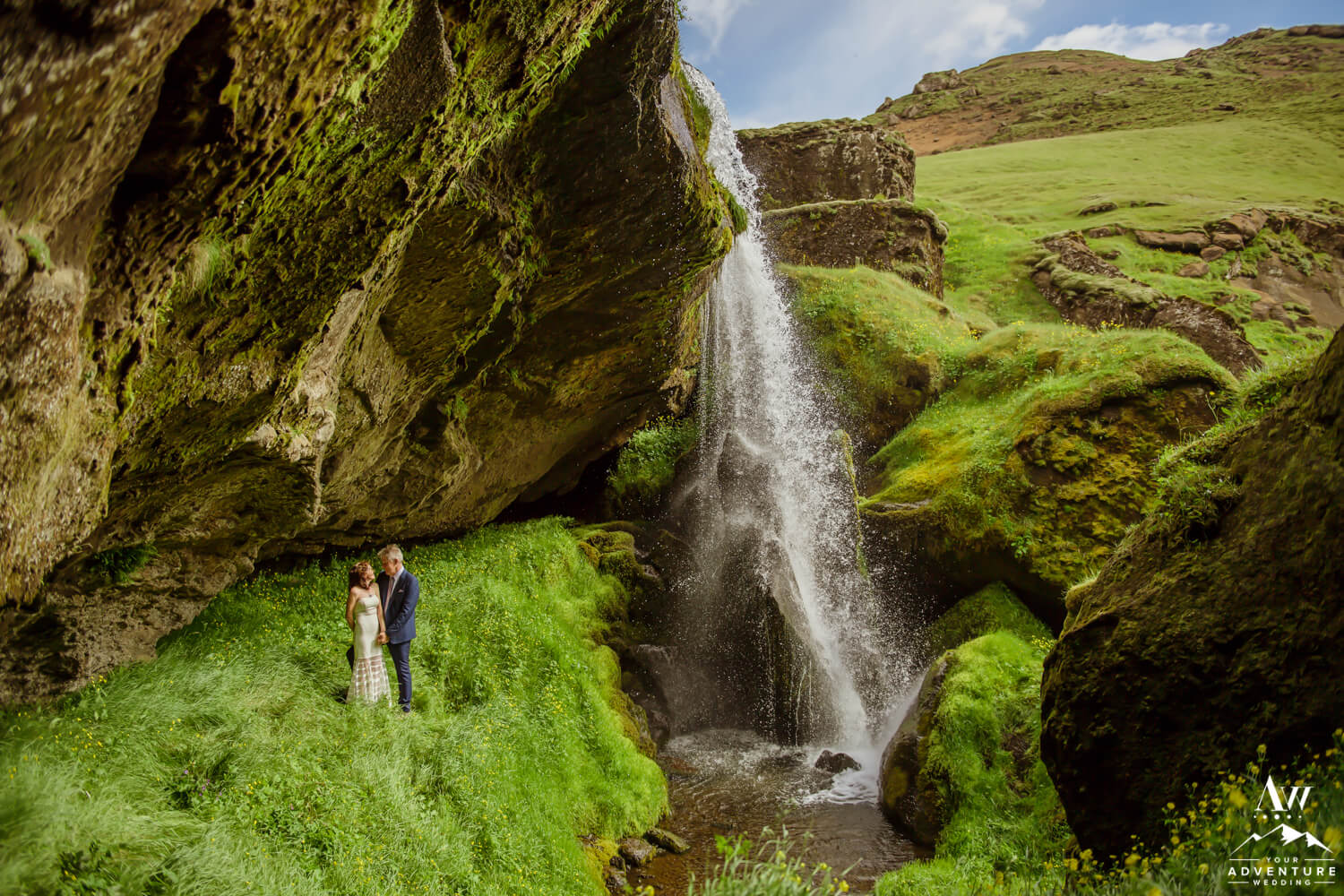 Iceland wedding couple standing behind a waterfall