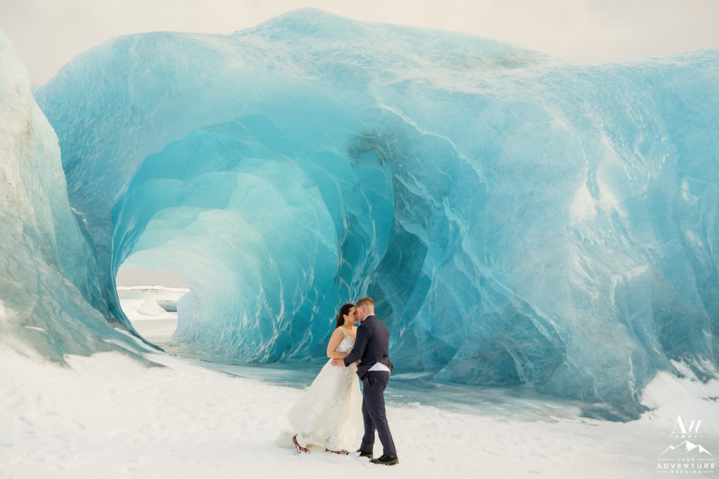 Couple kissing inside a blue ice cave