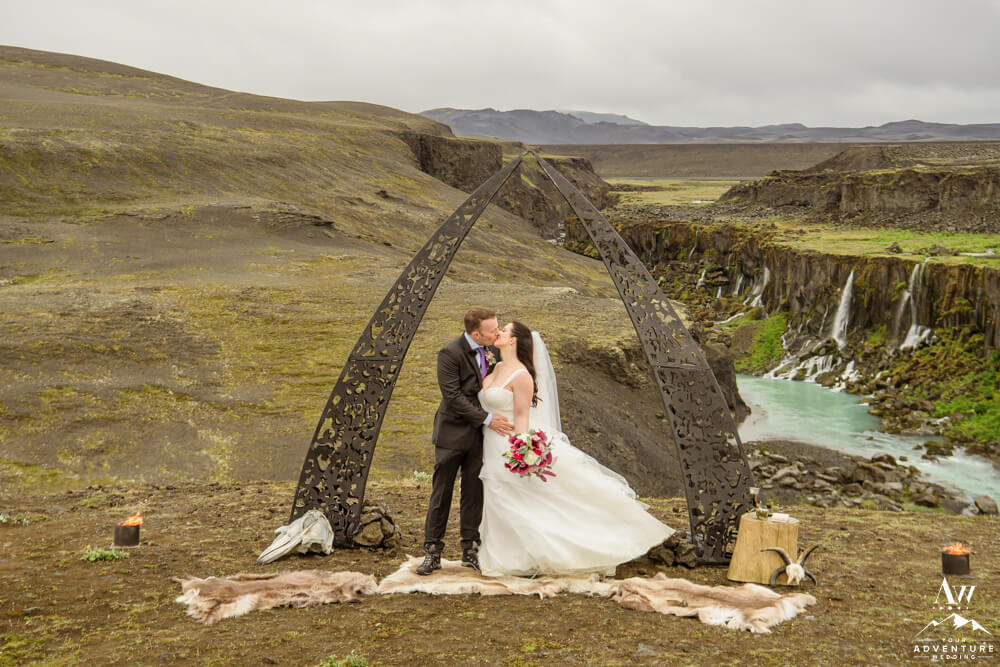 Iceland Elopement Couple under black arch at waterfall
