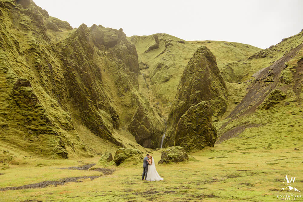 October Iceland Elopement Couple exploring a canyon waterfall