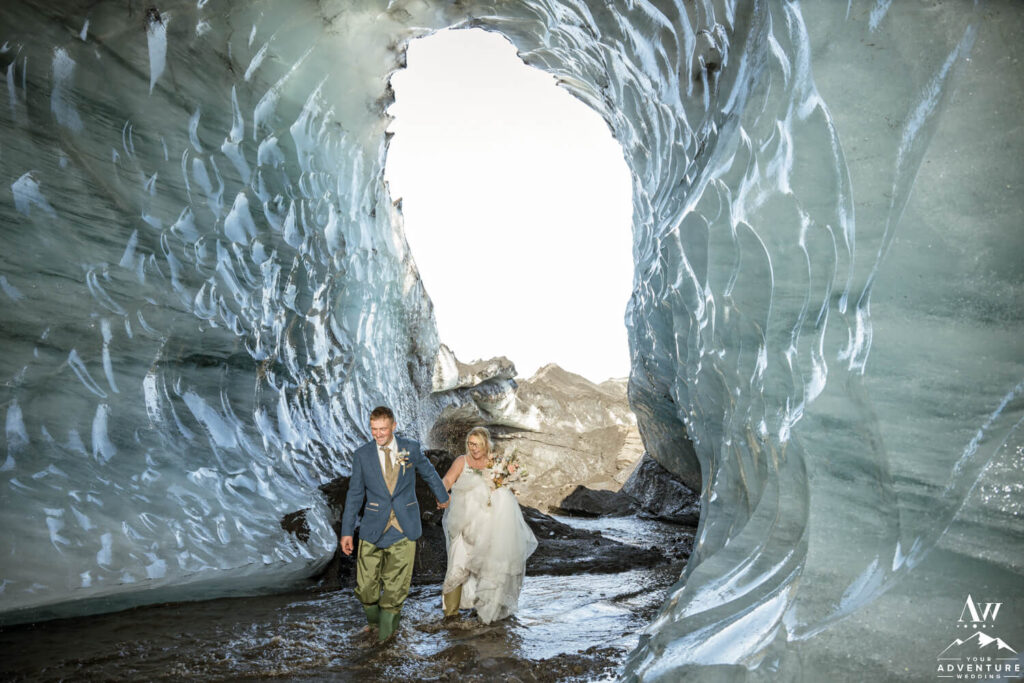 Unreal Iceland Elopement Couple walking through Ice Cave
